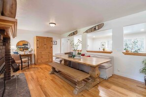 A spacious dining area with a wooden table and bench, surrounded by white walls and large windows. - All king beds (with 2 rooms that can convert into 2 twin XLs), hot tub, arcade, and fresh updates. Spacious, cozy, and minutes to Snowbird & Alta. Pet-friendly and perfect for ski groups wanting comfort, style, and unbeatable canyon access. (Sandy)