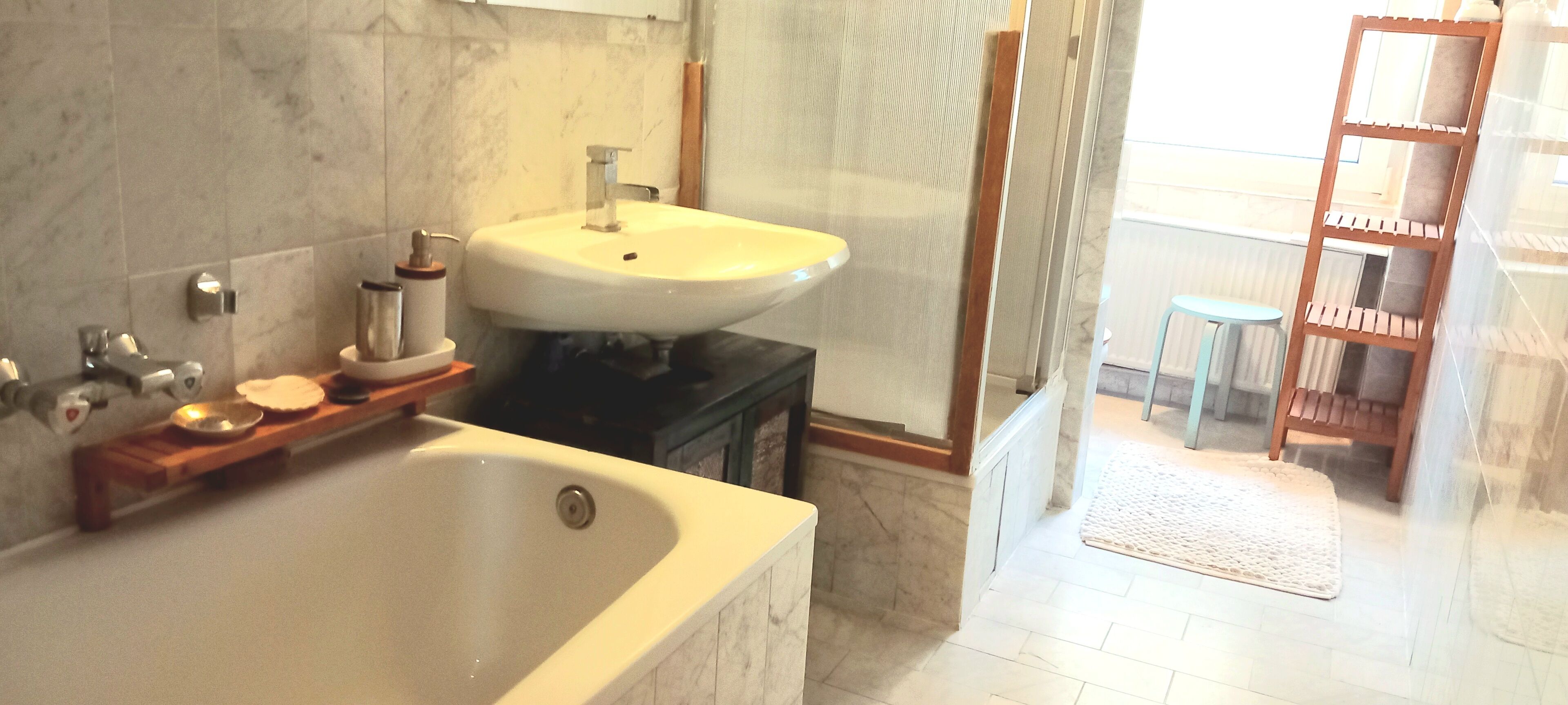 Un baño con bañera, lavamanos y zona de ducha.