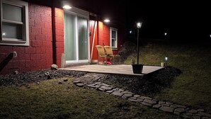 A building with a red brick exterior, a glass door, and a small outdoor seating area with two chairs. - Unique Farm Stay -Close to Colgate University, Hamilton College, Bouckville (Hubbardsville)