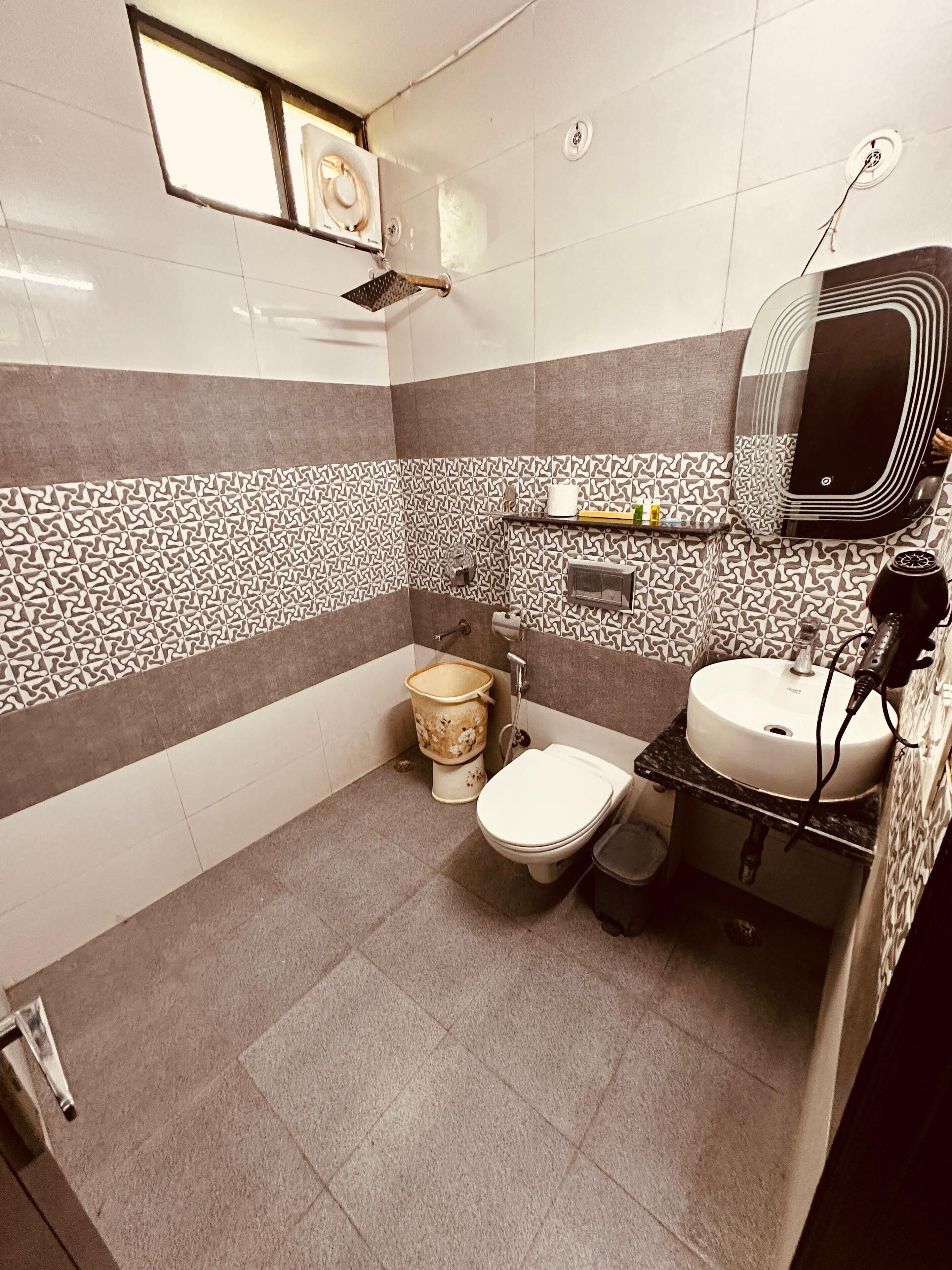 A bathroom with a toilet, sink, and shower.