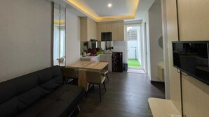A modern apartment with a living room, dining area, and kitchen.