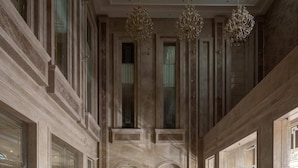 Un vaste hall d’entrée doté de sols en marbre, de lustres somptueux et d’une architecture de style classique.
