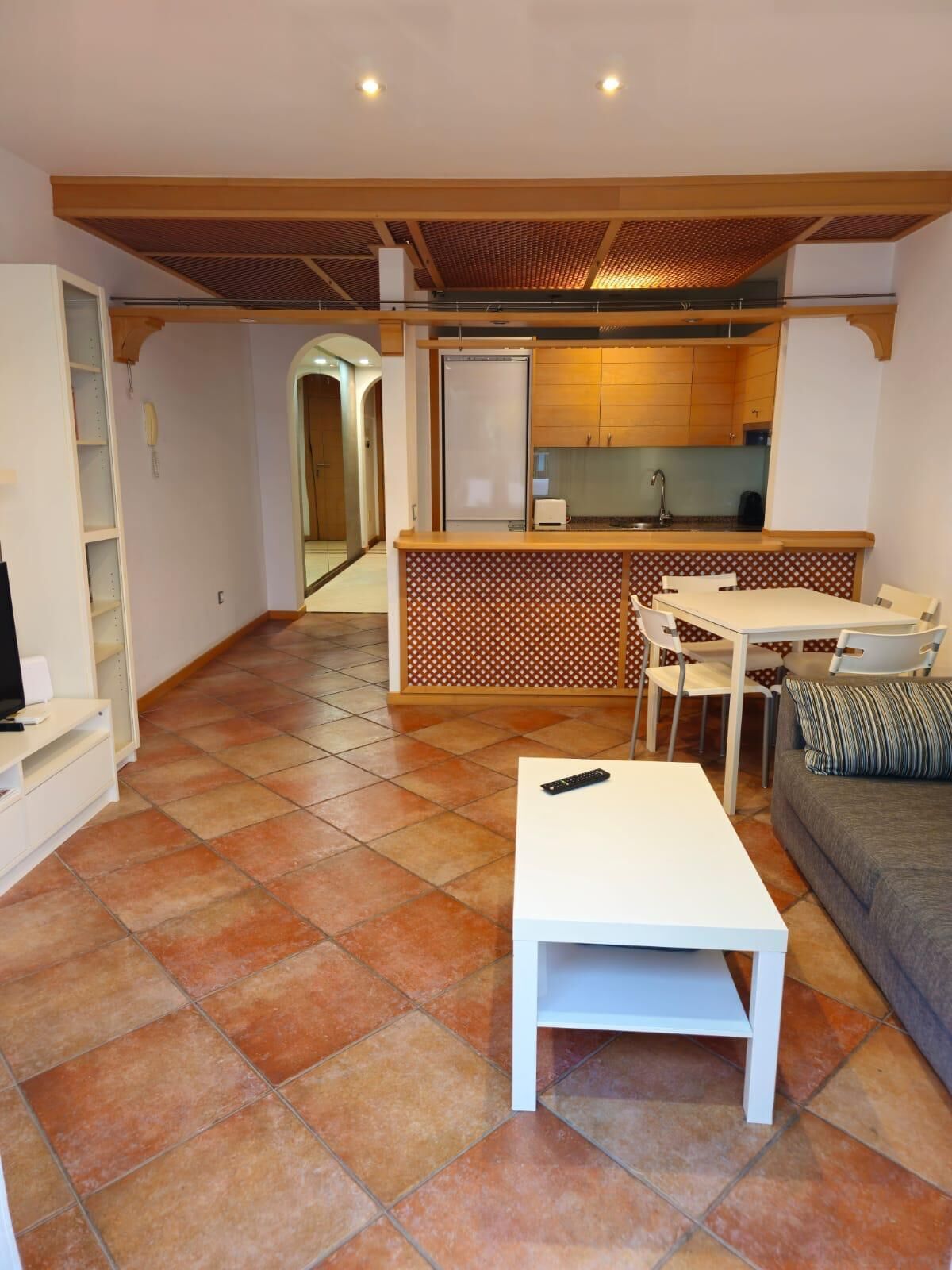 Un espai vital compacte amb cuina, zona de menjador i sofà.