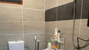 Un baño con inodoro, lavamanos y ducha.