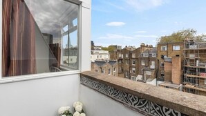 Ein Balkon mit Blick auf traditionelle Gebäude und Gerüst.