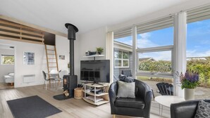 Una sala de estar moderna con chimenea, televisor y un espacio de estar cómodo.