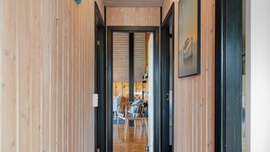 A wooden hallway leading to a room with a bed and a chair. - "Allin" - 350m from the sea by Interhome (Otterup)