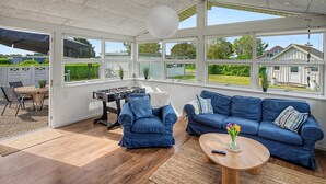 A sunroom with a foosball table, two blue sofas, and a wooden coffee table. - "Solvejg" - 280m from the sea by Interhome (Otterup)