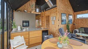 Een modern interieur met een keuken, een eethoek en zithoek.