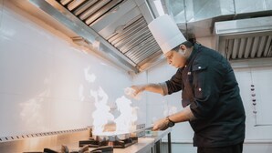A chef cooking with flames on a stove in a kitchen. - Ramat Niwas by Kutani Stays (Jaipur)