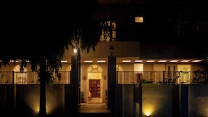Un edificio con entrada porticada, un corredor cubierto y una puerta visible que da a un espacio interior.