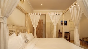 Un dormitorio con cama con dosel, cabecero de madera y dosel sobre la cama.