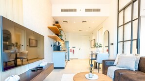 Rebedor modern d'hotel amb zona de seients, cuina i finestra gran.