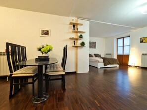 A modern living space with a dining area, a sofa, and a bed. - Il Giardino di Eleonora - Historic City Centre (Turin)