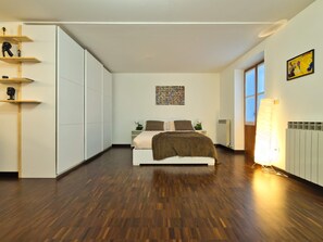 A bedroom with a bed, a radiator, a window, and a wall with a picture. - Il Giardino di Eleonora - Historic City Centre (Turin)