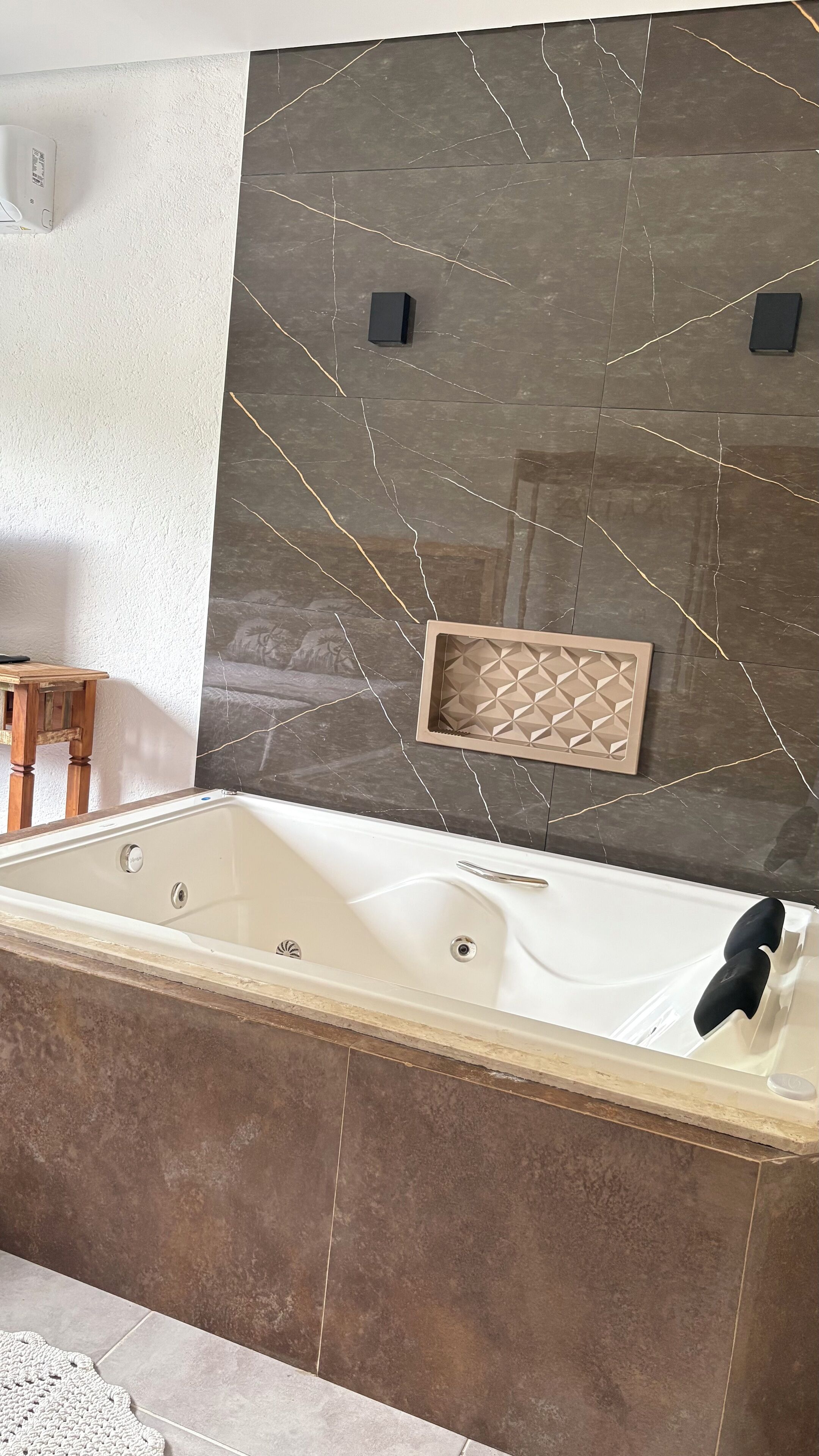 Une salle de bain moderne avec une baignoire sur pieds, une douche intégrée et un panneau mural décoratif.