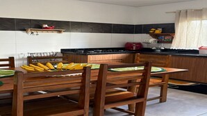 A kitchen with a dining table, chairs, and a countertop. - Village House in the Valley (Arraial d'Ajuda)