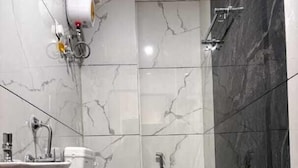 Een kleine badkamer met toilet, wastafel en douche.