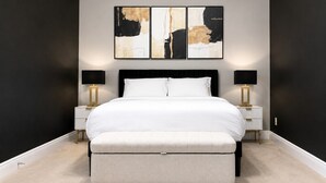 A bedroom with a large bed, bedside tables, and abstract wall art. - Walk to FSU, Downtown & the Capitol-PRIME location (Tallahassee)