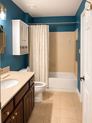 A bathroom with a bathtub, toilet, and vanity.