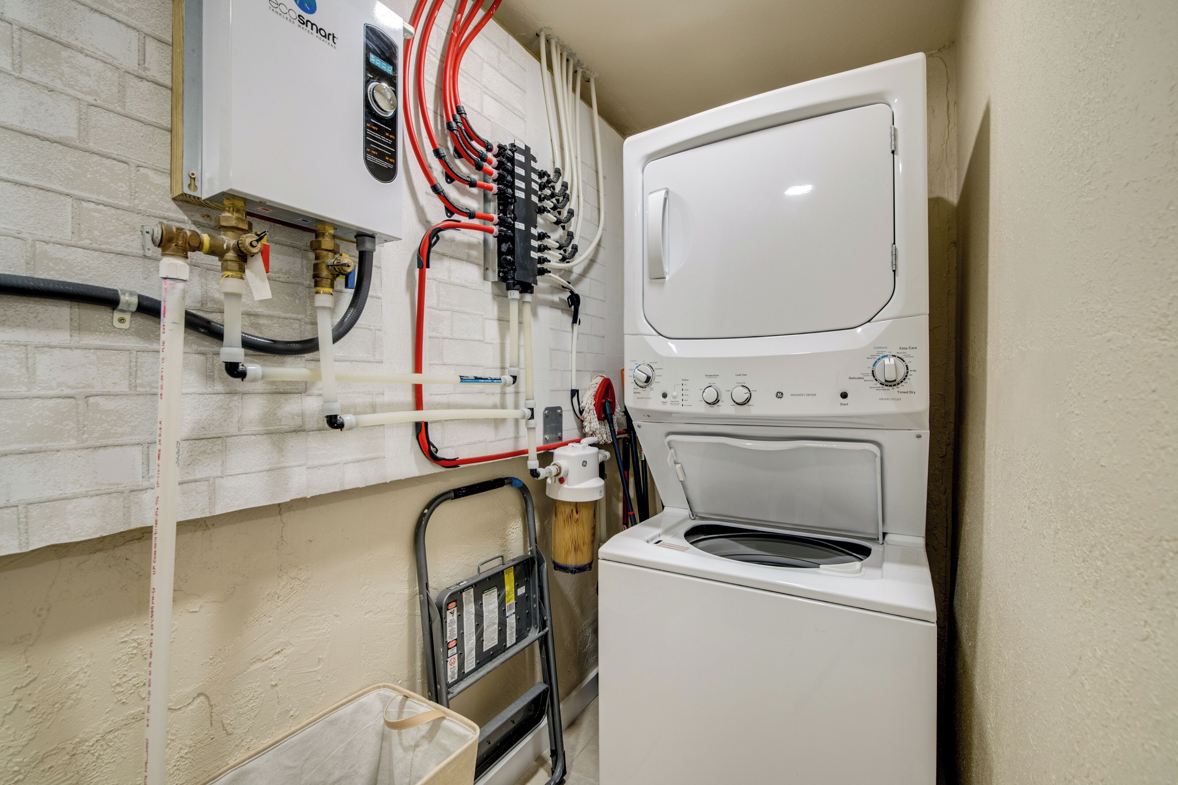 A compact laundry area with a washing machine and a water heater.