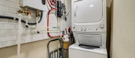 A compact laundry area with a washing machine and a water heater.