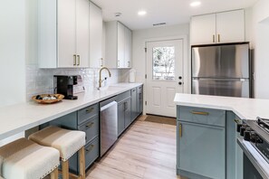 A modern kitchen with white cabinets, a stainless steel refrigerator, and a built-in oven. - Near NAU & Dtwn! Kid-friendly Flagstaff Retreat (Flagstaff)