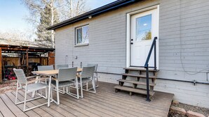 Une petite maison avec une terrasse, une porte et une fenêtre.