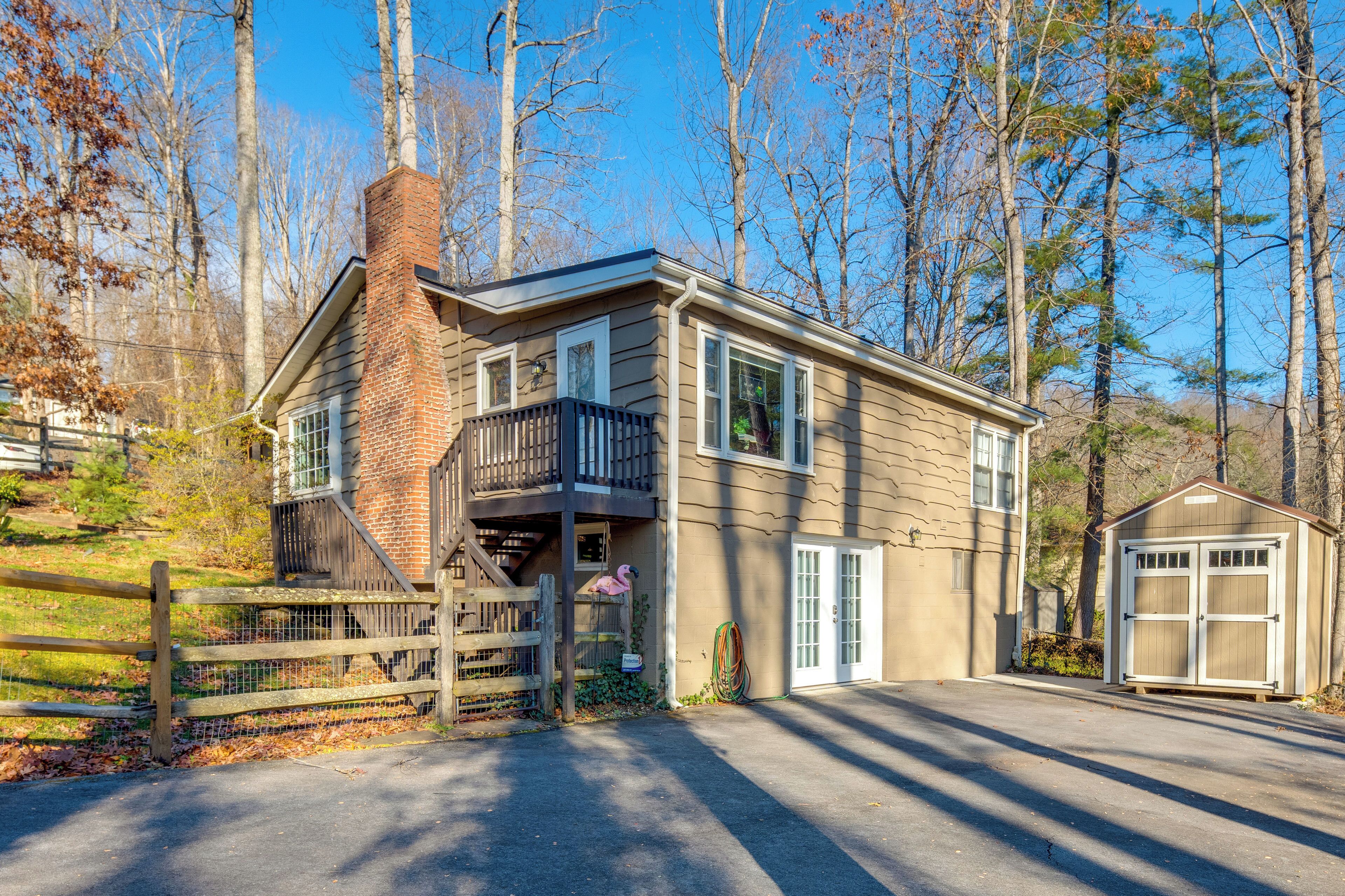 A two-story house with a balcony, a garage, and a fenced driveway.