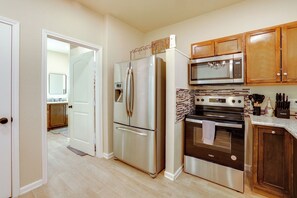 A modern kitchen with stainless steel appliances, wooden cabinets, and a tiled backsplash. - Hill Country Casita Near Guadalupe River! (Bulverde)