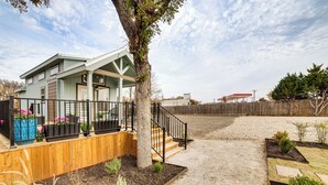 A two-story house with a covered porch, a wooden deck, and a fenced yard.