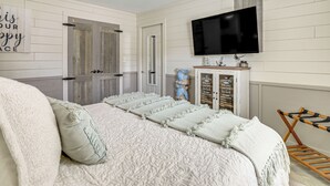 A bedroom with a bed, a television, a cabinet with books, and a ceiling fan. - 'dunns Creek Lodge' - Private Boat Ramp! (Satsuma)