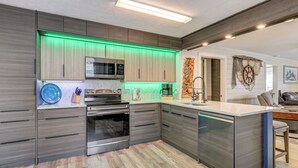 A modern kitchen with built-in appliances, a central island, and a unique wall decoration. - 'dunns Creek Lodge' - Private Boat Ramp! (Satsuma)