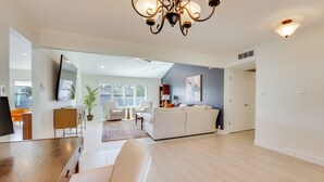 A spacious living area with a large sofa, a dining table, and a chandelier. - Pool + Putting Green: Quiet Scottsdale Oasis! (Scottsdale)
