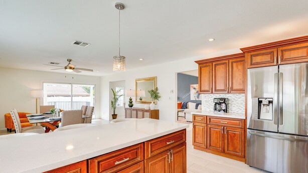 A modern kitchen with wooden cabinets, a stainless steel refrigerator, and a large island. - Pool + Putting Green: Quiet Scottsdale Oasis! (Scottsdale)