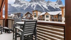 Un lodge de montaña con varias construcciones tipo chalet, barandales de madera y vistas a picos nevados.