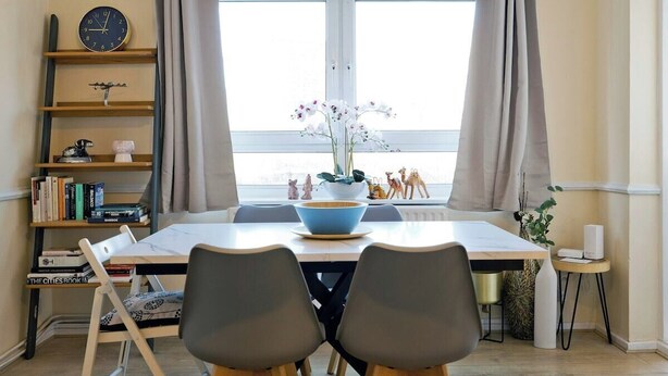 A dining area with a table, chairs, a clock, and a window with curtains. - Little Venice in Paddington central London 3 bedroom apartment (London)