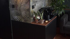 Una cocina moderna con encimera de madera, una cafetera y una planta en maceta.