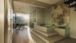Ein modernes Badezimmer mit Marmorwand, einer Badewanne und einer Duschkabine.