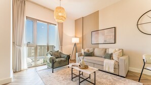 Ett modernt vardagsrum med en soffa, fåtöljer, ett soffbord och en golvlampa.