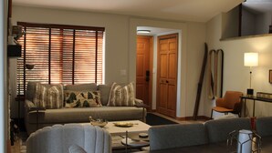A living room with a sofa, armchairs, a coffee table, and a lamp. - Beautifully Remodeled Townhome on Peak 8 (Breckenridge)