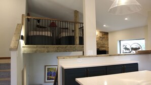 A modern kitchen with dark cabinets, a white countertop, and a hanging light fixture. - Beautifully Remodeled Townhome on Peak 8 (Breckenridge)
