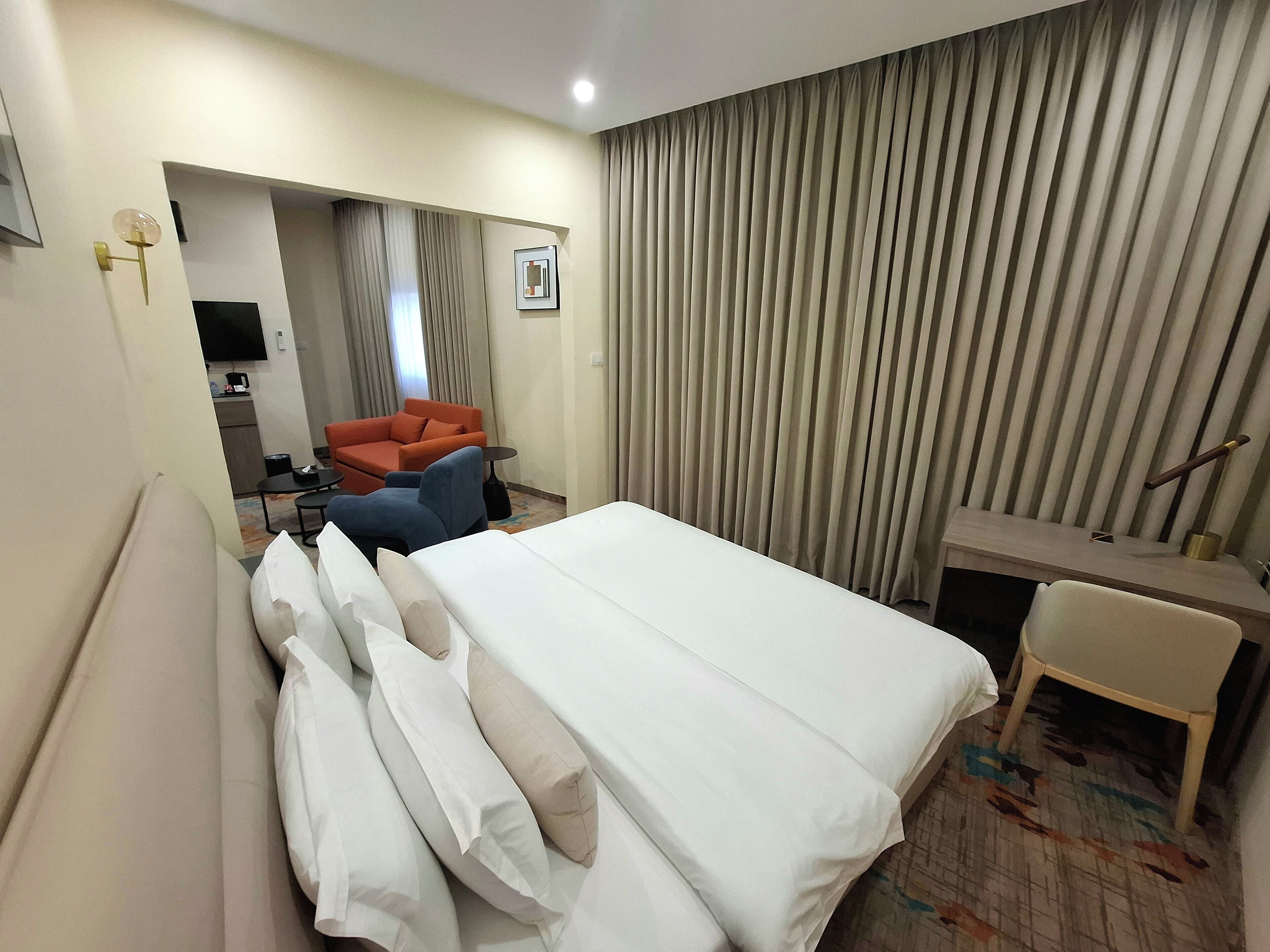 Suite – junior, balkong, byutsikt | Safe på rommet, skrivebord og skrivebord for bærbar PC