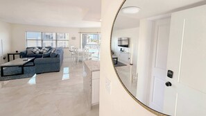 A modern living room with a sofa, coffee table, and dining area. - Island House Beach Club #4A Luxe Beachfront Condo (Fort Myers Beach)