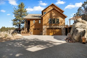 A two-story wooden house with a stone foundation, a front porch, and a garage. - Boulder Cove Lakefront Estate (Big Bear Lake)