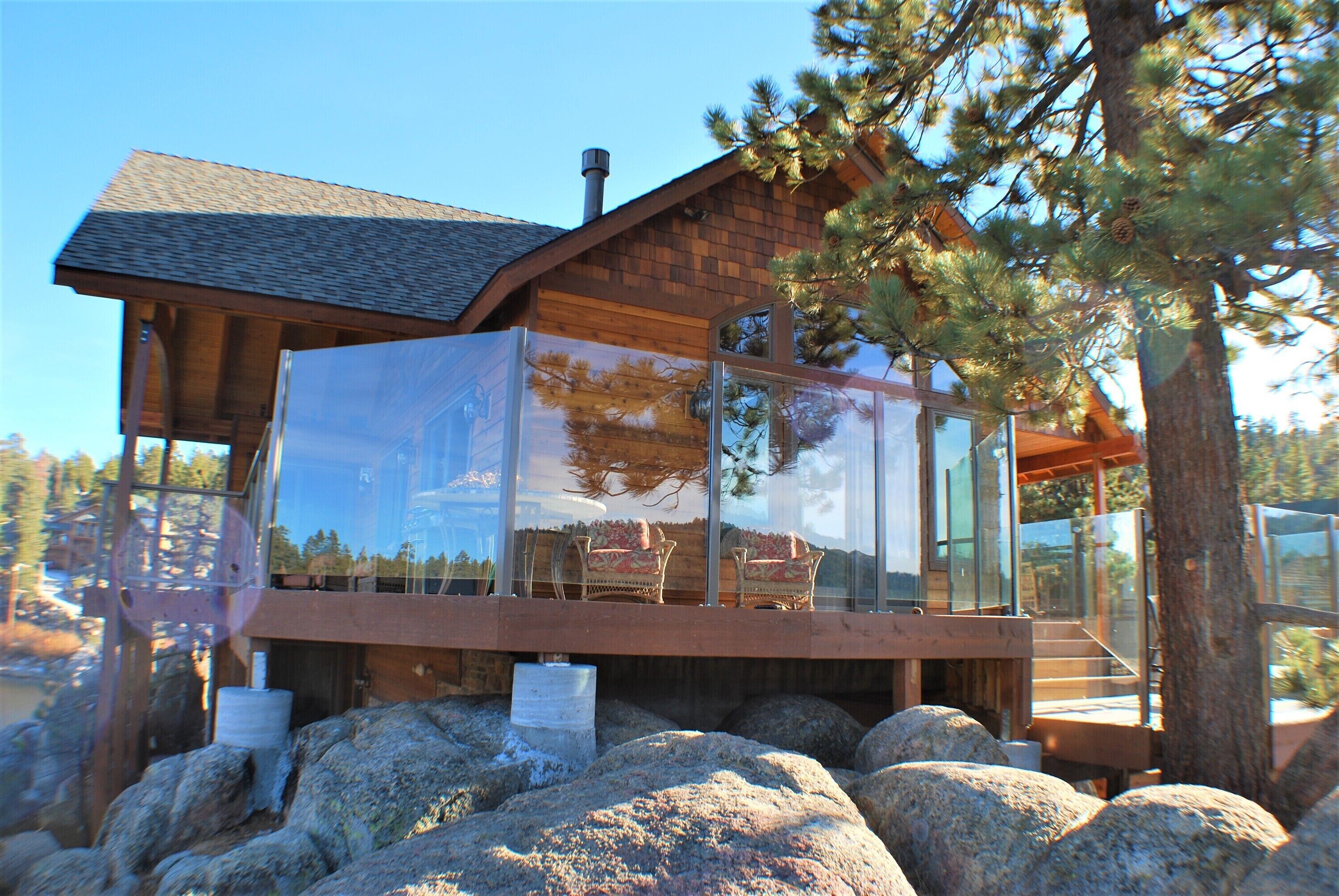Une cabane dotée d’une paroi vitrée, d’un revêtement extérieur en bois et offrant une vue sur le paysage environnant.