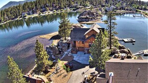 A lakeside lodge with a dock, surrounded by dense forest and a mountain backdrop. - Boulder Cove Lakefront Estate (Big Bear Lake)