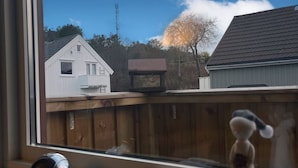 Een uitzicht op een huis, een houten hek en een heldere lucht.