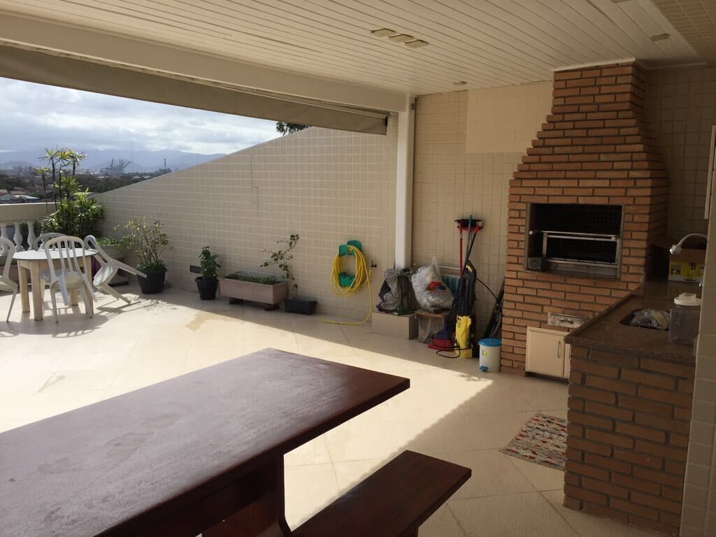 An outdoor patio with a brick oven, a table, and chairs.