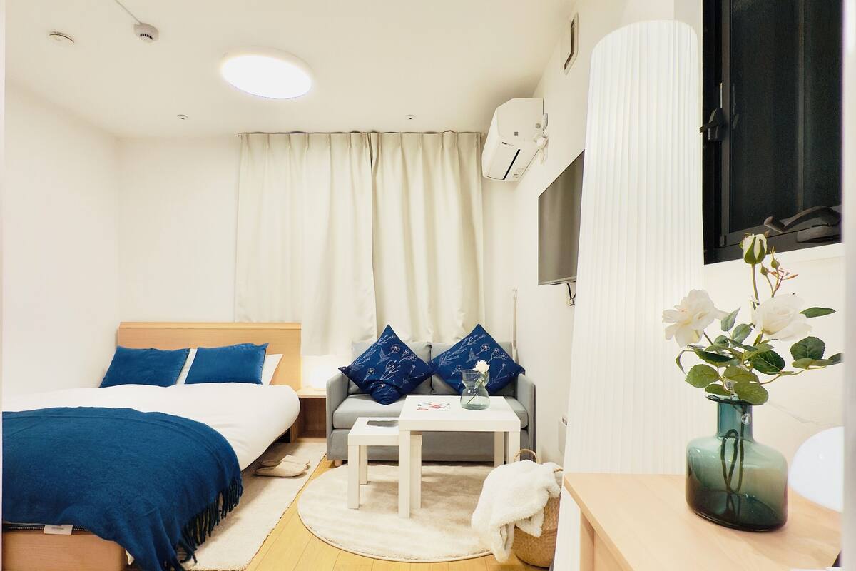 Una habitación de hotel moderna con una cama, un sofá, una mesita y un escritorio.